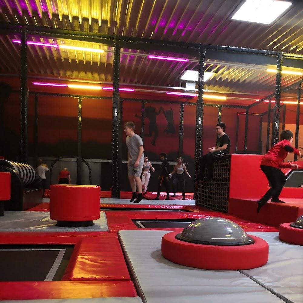 A trampoline park with red and gray padding.